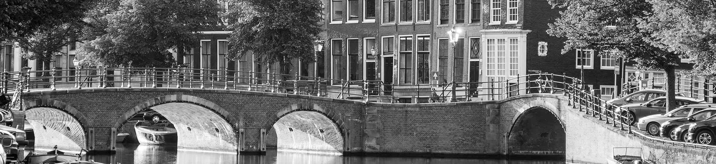 Zwart-witfoto van een brug over een Amsterdamse gracht