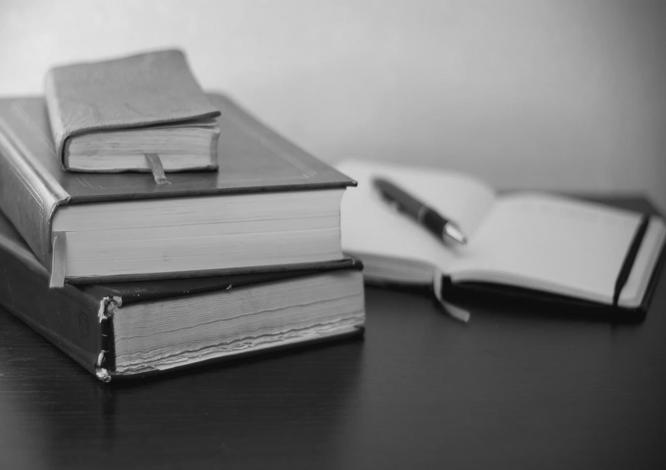 Zwart-witfoto van juridische boeken en een vulpen